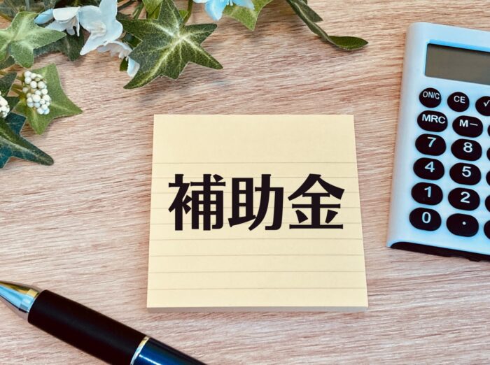 住宅購入の資金計画と「補助金」と書かれたメモ・電卓
