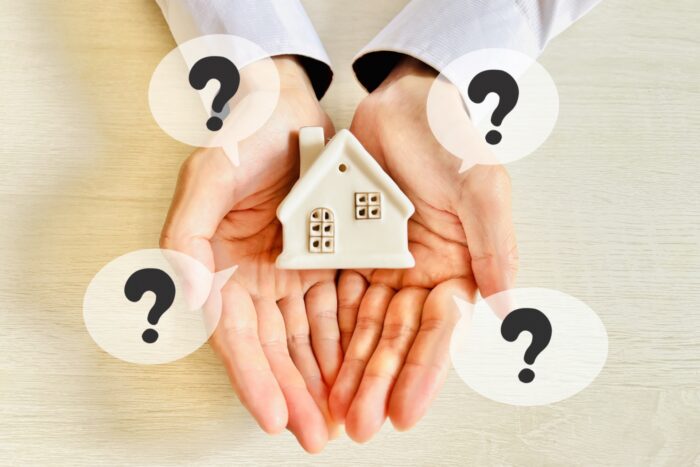 親から住宅資金を借りるかもらうか検討する様子を表す家の模型と疑問符